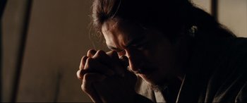 Movie still from “Silence” (2016), directed by Martin Scorsese – A person with his hands clasped together; Close Up shot, Low angle
