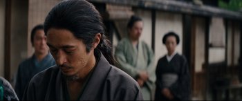 Movie still from “Silence” (2016), directed by Martin Scorsese – A man with long black hair wearing a black robe; Close Up shot, Over the shoulder angle