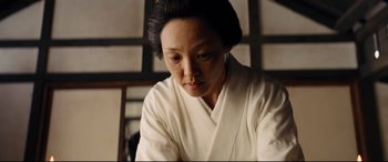 Movie still from “Silence” (2016), directed by Martin Scorsese – An asian woman in a white robe looking down at the floor; Close Up shot, Low angle