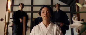 Movie still from “Silence” (2016), directed by Martin Scorsese – A man in a white robe is looking at the camera; Medium shot, Low angle