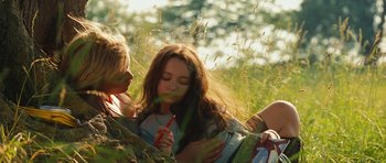Movie still from “Silent Hill” (2006), directed by Christophe Gans – Two people in a grassy field with one of them holding a pencil; Medium shot, Low angle