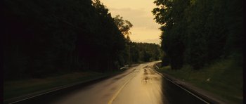 Movie still from “Silent Hill” (2006), directed by Christophe Gans – A wet road with trees in the background; Extreme Wide shot, High angle