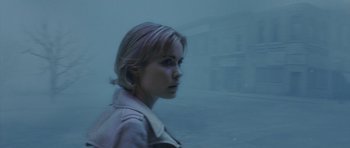 Movie still from “Silent Hill” (2006), directed by Christophe Gans – A woman is standing in the fog outside of a building; Close Up shot, Over the shoulder angle