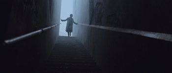 Movie still from “Silent Hill” (2006), directed by Christophe Gans – A woman walking up a set of stairs; Wide shot, Low angle