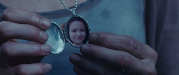 Movie still from “Silent Hill” (2006), directed by Christophe Gans – A hand holding a locket with a picture of a girl in it; Extreme Close Up shot, High angle