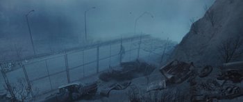 Movie still from “Silent Hill” (2006), directed by Christophe Gans – A car parked on the side of a road near a fence; Extreme Wide shot, High angle