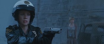 Movie still from “Silent Hill” (2006), directed by Christophe Gans – A police officer holding a gun in front of a woman; Close Up shot, Over the shoulder angle