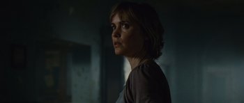 Movie still from “Silent Hill” (2006), directed by Christophe Gans – A woman standing in a dark room looking to her left; Close Up shot, Low angle