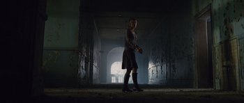 Movie still from “Silent Hill” (2006), directed by Christophe Gans – A woman standing in an abandoned building holding a knife in one hand; Wide shot, Low angle