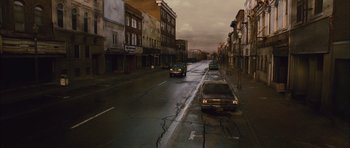 Movie still from “Silent Hill” (2006), directed by Christophe Gans – Cars driving down a street in a city; Extreme Wide shot, High angle