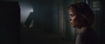 Movie still from “Silent Hill” (2006), directed by Christophe Gans – A woman looking into the distance in a dark room; Close Up shot, Low angle