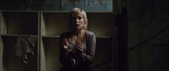 Movie still from “Silent Hill” (2006), directed by Christophe Gans – A woman holding a pair of handcuffs in a room; Medium shot, High angle