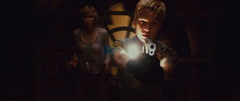 Movie still from “Silent Hill” (2006), directed by Christophe Gans – A woman and a boy holding a gun in a dark room; Medium shot, Low angle