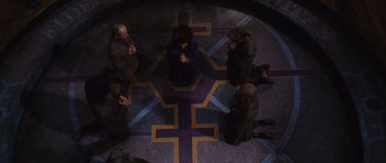 Movie still from “Silent Hill” (2006), directed by Christophe Gans – A group of people sitting in a circle on the ground; Wide shot, Overhead angle