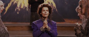 Movie still from “Silent Hill” (2006), directed by Christophe Gans – A woman in a purple jacket with her hands in prayer position; Medium shot, Low angle