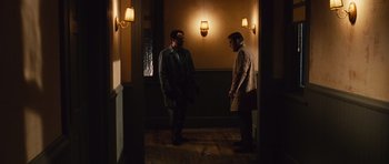 Movie still from “Silent Hill” (2006), directed by Christophe Gans – Two men standing in a hallway in front of a wall; Wide shot, Over the shoulder angle