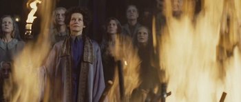 Movie still from “Silent Hill” (2006), directed by Christophe Gans – A group of people standing next to a fire pit; Medium shot, Low angle