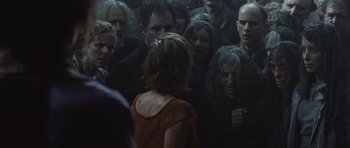 Movie still from “Silent Hill” (2006), directed by Christophe Gans – A group of people gathered around a woman in a red dress; Medium shot, Over the shoulder angle