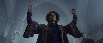 Movie still from “Silent Hill” (2006), directed by Christophe Gans – A person with their hands up in the air in front of an archway; Medium shot, Low angle