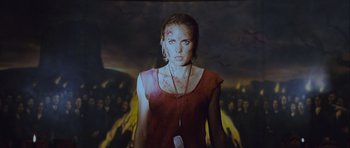 Movie still from “Silent Hill” (2006), directed by Christophe Gans – A woman in a red dress is standing in front of flames; Medium shot, Low angle