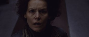 Movie still from “Silent Hill” (2006), directed by Christophe Gans – A woman's face in a dimly - lit room; Close Up shot, Low angle