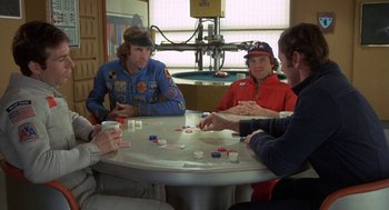 Movie still from “Silent Running” (1972), directed by Douglas Trumbull – A group of people sitting at a table playing cards; Medium shot, High angle