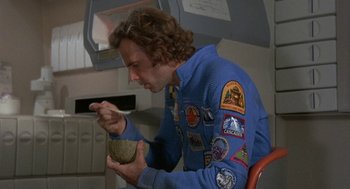 Movie still from “Silent Running” (1972), directed by Douglas Trumbull – A man in a space suit eats a bowl of cereal; Medium shot, Low angle