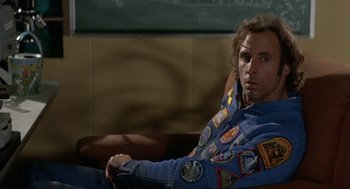 Movie still from “Silent Running” (1972), directed by Douglas Trumbull – A man sitting on a couch with patches on his jacket; Close Up shot, Over the shoulder angle