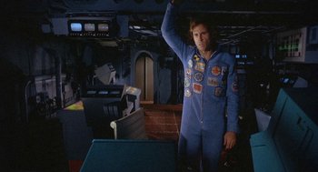 Movie still from “Silent Running” (1972), directed by Douglas Trumbull – A man in a space suit standing next to a table; Medium shot, Overhead angle