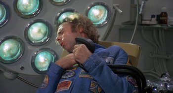Movie still from “Silent Running” (1972), directed by Douglas Trumbull – A man in a space suit is holding a phone; Medium shot, Overhead angle