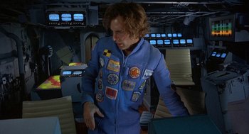 Movie still from “Silent Running” (1972), directed by Douglas Trumbull – A man in a blue suit with patches on his jacket; Medium shot, Overhead angle