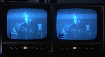 Movie still from “Silent Running” (1972), directed by Douglas Trumbull – Two televisions with a man on the top and another man on the bottom of the screen; Close Up shot, Over the shoulder angle