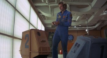 Movie still from “Silent Running” (1972), directed by Douglas Trumbull – A man standing next to some boxes in a room; Wide shot, Low angle