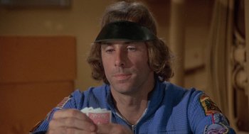 Movie still from “Silent Running” (1972), directed by Douglas Trumbull – A man with long brown hair wearing a black hat; Close Up shot, Over the shoulder angle