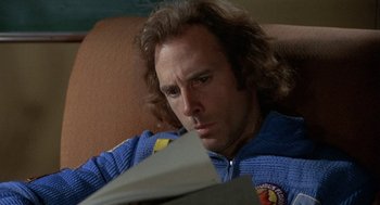 Movie still from “Silent Running” (1972), directed by Douglas Trumbull – A man sitting in a chair reading a book; Close Up shot, Low angle