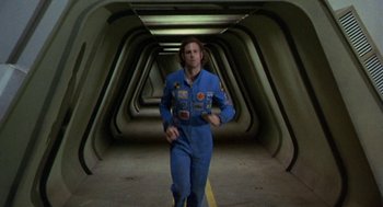 Movie still from “Silent Running” (1972), directed by Douglas Trumbull – A man in a space suit is walking through a tunnel; Wide shot, Overhead angle