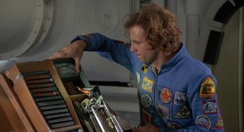 Movie still from “Silent Running” (1972), directed by Douglas Trumbull – A man in a blue jacket is working on a machine; Medium shot, Overhead angle