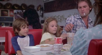 Movie still from “Silkwood” (1983), directed by Mike Nichols – A group of people sitting at a table eating food; Medium shot, Over the shoulder angle