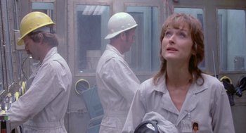Movie still from “Silkwood” (1983), directed by Mike Nichols – A woman in a hard hat and white overalls looking off into the distance; Close Up shot, Low angle