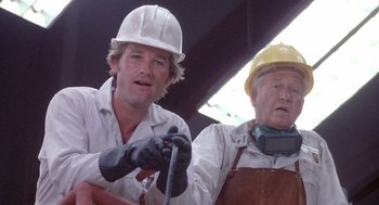 Movie still from “Silkwood” (1983), directed by Mike Nichols – Two men wearing hard hats and gloves are working; Close Up shot, Low angle