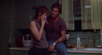 Movie still from “Silkwood” (1983), directed by Mike Nichols – A man and a woman sitting on a counter; Medium shot, Low angle
