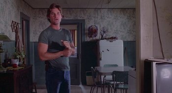 Movie still from “Silkwood” (1983), directed by Mike Nichols – A man standing in front of an old fashioned refrigerator; Medium shot, Low angle