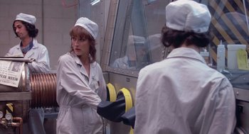 Movie still from “Silkwood” (1983), directed by Mike Nichols – A woman in a white lab coat and a man in white lab coat; Medium shot, Over the shoulder angle