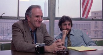 Movie still from “Silkwood” (1983), directed by Mike Nichols – Two men sitting at a table with a cup of coffee; Medium shot, Low angle