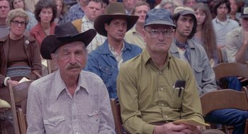 Movie still from “Silkwood” (1983), directed by Mike Nichols – A group of men sitting next to each other in a room; Medium shot, High angle