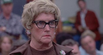 Movie still from “Silkwood” (1983), directed by Mike Nichols – An older woman wearing glasses and a brown jacket; Close Up shot, Over the shoulder angle