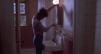 Movie still from “Silkwood” (1983), directed by Mike Nichols – A woman is washing her hands in a bathroom; Medium shot, Low angle
