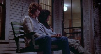 Movie still from “Silkwood” (1983), directed by Mike Nichols – Two women sitting on a porch swing in front of a window; Wide shot, Low angle