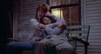 Movie still from “Silkwood” (1983), directed by Mike Nichols – Two women sitting on a bench hugging each other; Medium shot, Low angle