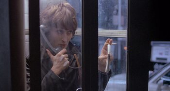 Movie still from “Silkwood” (1983), directed by Mike Nichols – A woman is looking out of a window at a cigarette; Close Up shot, Low angle